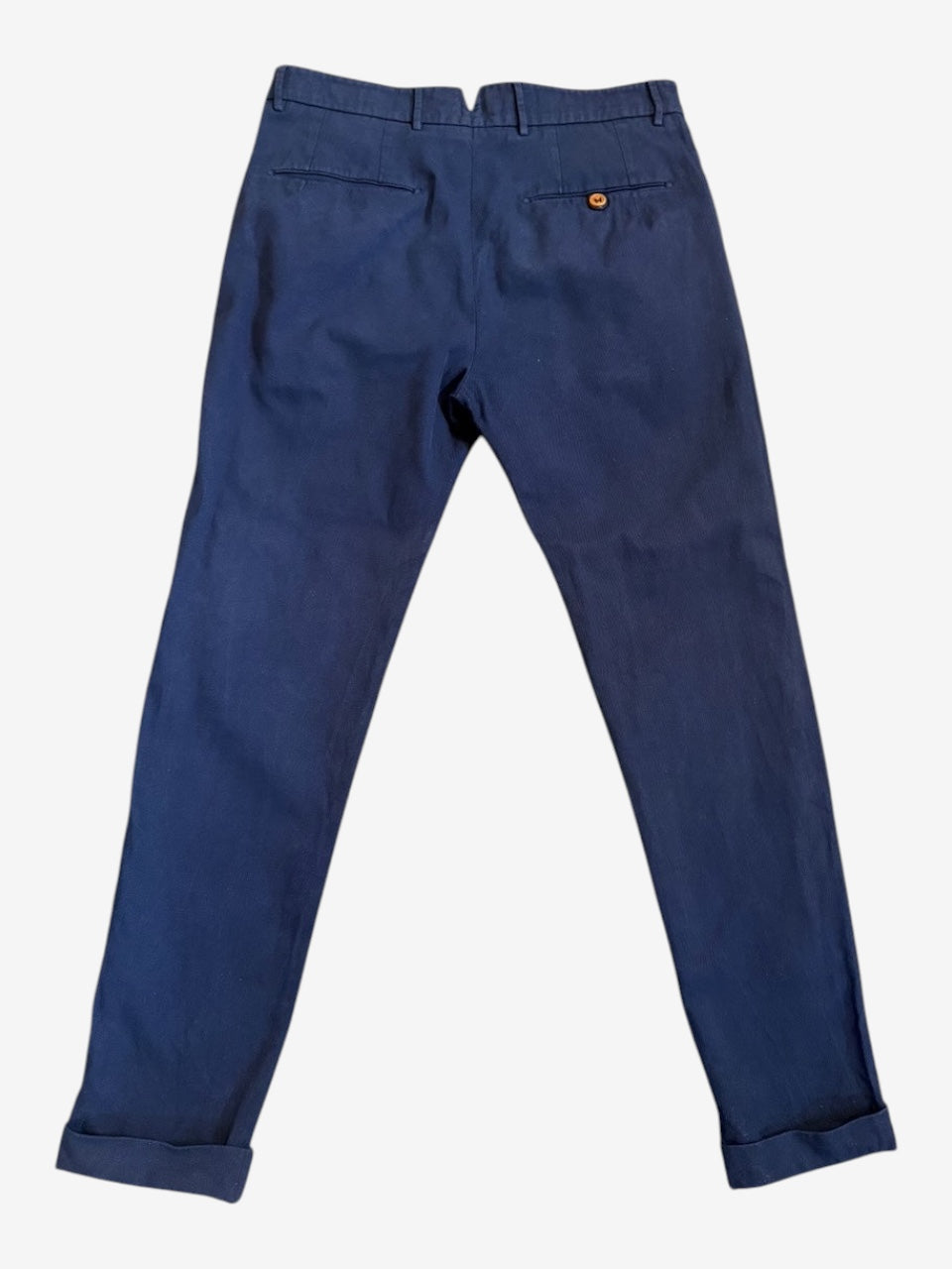 Nordic Jeans Co. navy tailored cotton chino trousers with back pockets and cuffed hems, back view.