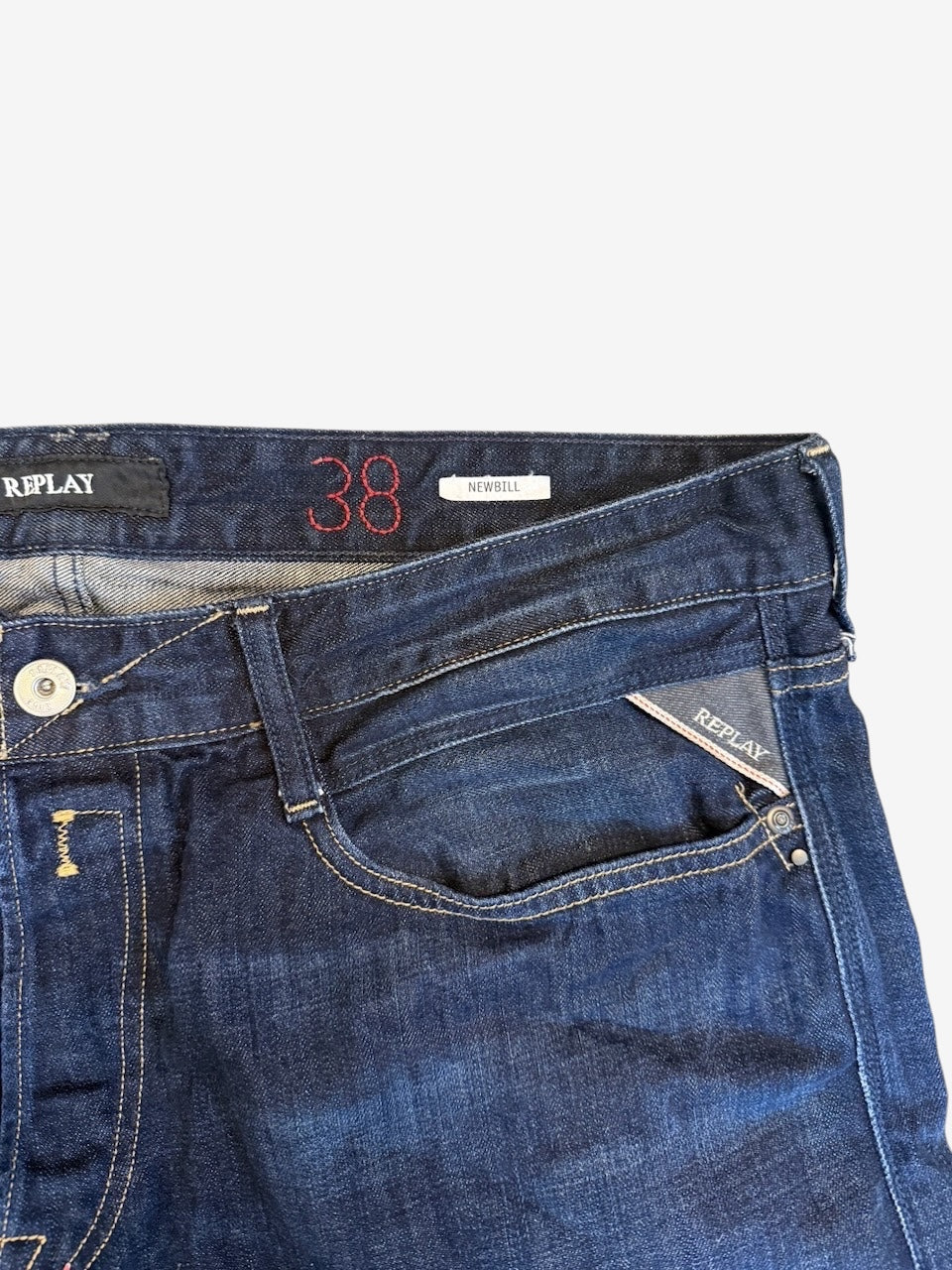 Nordic Jeans Co. REPLAY Newbill dark indigo denim jeans featuring contrast stitching and signature logo detailing.