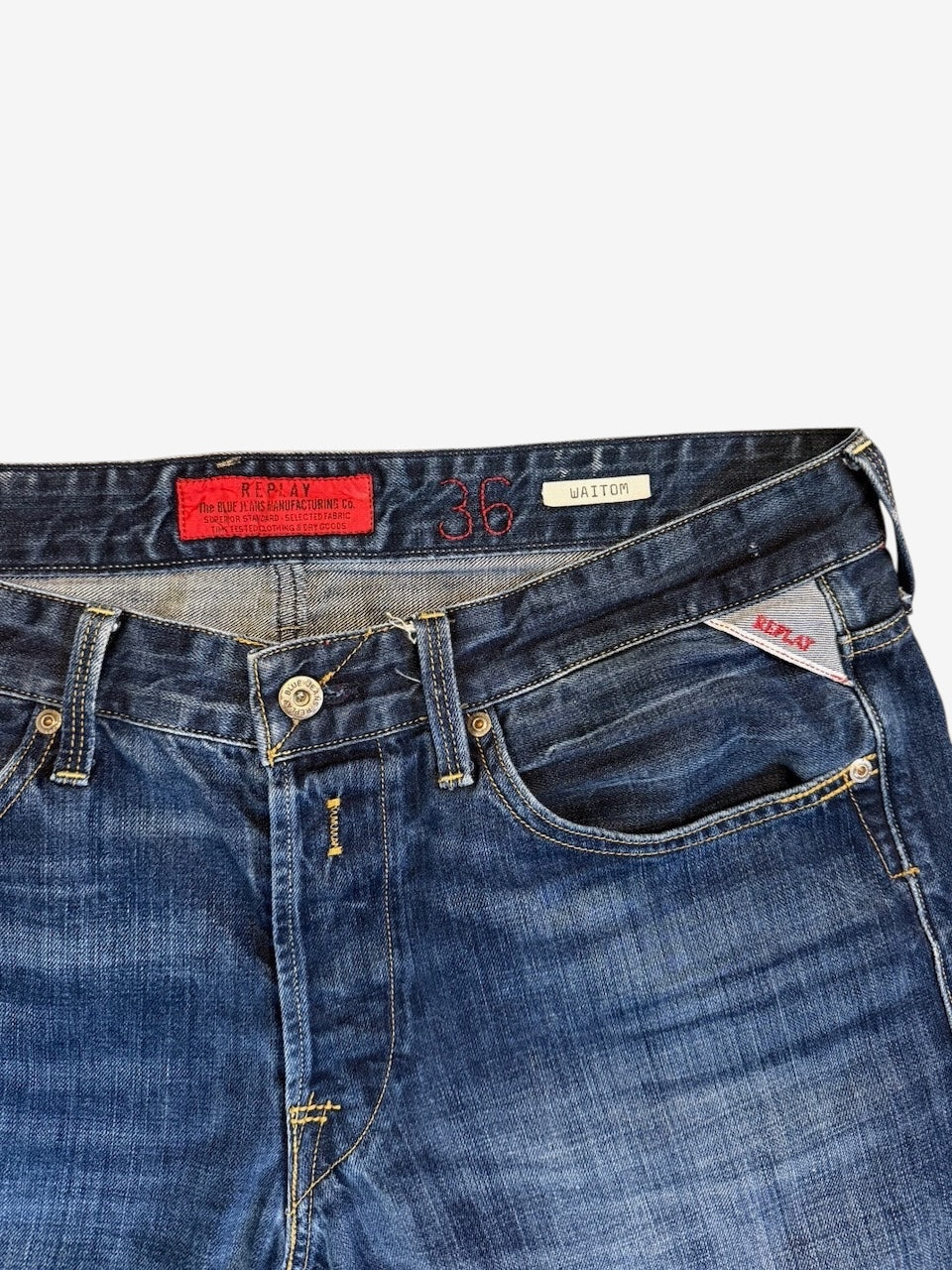 Nordic Jeans Co. REPLAY Waitom regular fit medium-wash blue denim jeans with red brand patch and button fly detail.